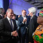 German Chancellor Olaf Scholz speaks with World Trade Organization Director-General Ngozi Okonjo-Iweala (right) as he left the stage after his speech