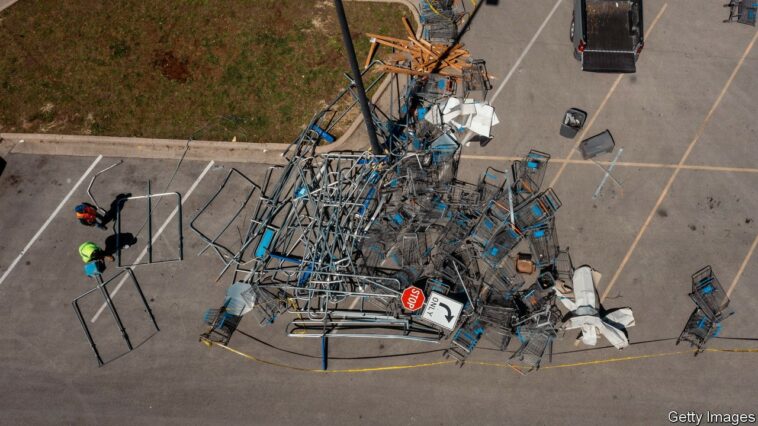 Workers clear debris from a Walmart store parking lot following a tornado in Round Rock, Texas, U.S., on Tuesday, March 22, 2022. There were 22 reports of tornadoes, mainly across eastern Texas, as well as one in Oklahoma, according to the Storm Prediction Center. Photographer: Jordan Vonderhaar/Bloomberg via Getty Images