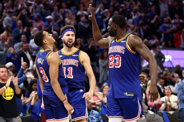 Jordan Poole #3 of the Golden State Warriors is congratulated by Klay Thompson #11 and Draymond Green #23 after making a three point basket against the Utah Jazz in the fourth quarter at Chase Center on April 02, 2022 in San Francisco, California.