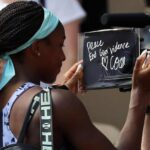 Coco Gauff writes “Peace. End gun violence” on the camera after winning against Martina Trevisan