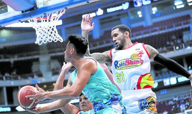 Javee Mocon of Phoenix (left) slithers past Nick Demusis for a reverse layup in the second half of a tight win for the Fuel Masters. —PHOTOS FROM PBA IMAGES