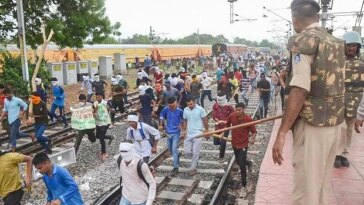 Youngsters being chased away by police personnel during their protest against governments newly introduced Agnipath scheme, at Birlanagar Junction railway station, in Gwalior (Photo: PTI)