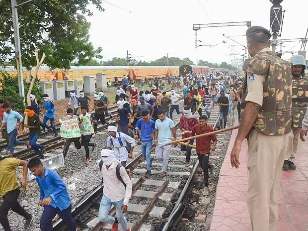 Youngsters being chased away by police personnel during their protest against governments newly introduced Agnipath scheme, at Birlanagar Junction railway station, in Gwalior (Photo: PTI)