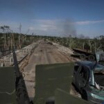 Members of a foreign volunteers unit which fights in the Ukrainian army drive on a military vehicle, as Russia