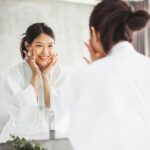 Woman in bathroom aleaning her face