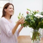 A beautiful woman arranging a bouquet of flowers at home