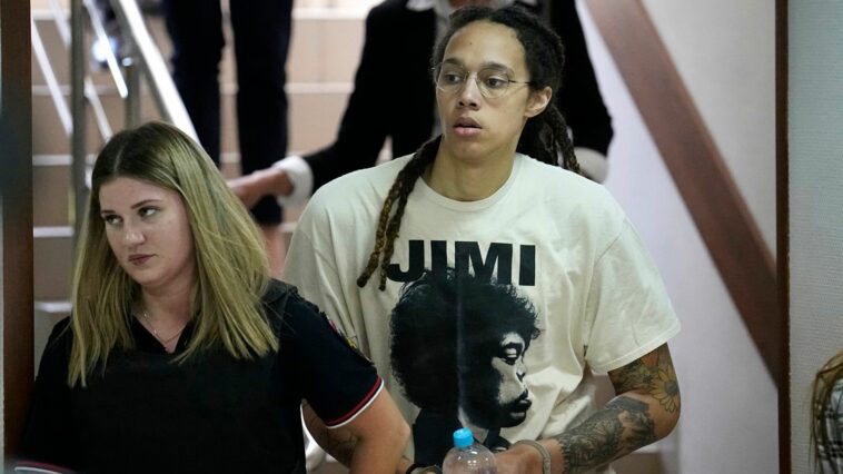 WNBA star and two-time Olympic gold medalist Brittney Griner is escorted to a courtroom for a hearing, in Khimki just outside Moscow, Russia, Friday, July 1, 2022. U.S. basketball star Brittney Griner is set to go on trial in a Moscow-area court Friday. The proceedings that are scheduled to begin Friday come about 4 1/2 months after she was arrested on cannabis possession charges at an airport while traveling to play for a Russian team. (AP Photo/Alexander Zemlianichenko)