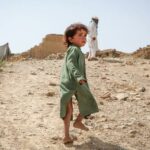 A boy walks up the hill to his former home, destroyed by the earthquake that hit Afghanistan in June 2022 .