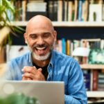 man smiling at laptop