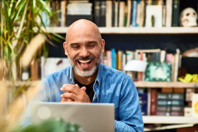 man smiling at laptop