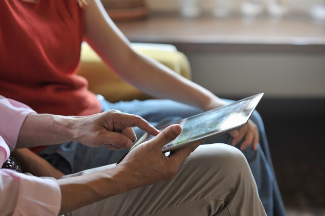 Senior man is using a digital tablet in living