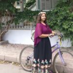 Rahma standing outside with a bicycle