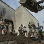 Young volunteers clear debris from a building destroyed by a Russian rocket.