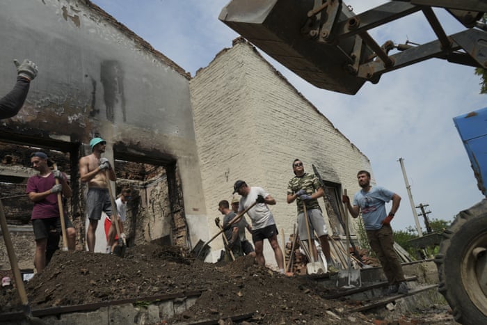 Young volunteers clear debris from a building destroyed by a Russian rocket.