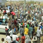 Scores of Hausa people gather outside local government offices in Port Sudan, on the Red Sea