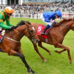 William Buick celebrates as he beats Frankie Dettori to win the Irish Derby on Hurricane Lane