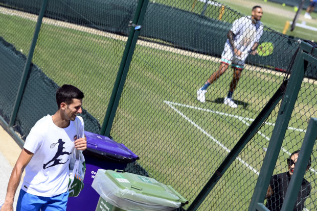 Tennis - Wimbledon - All England Lawn Tennis and Croquet Club, London, Britain - July 9, 2022  Australia's Nick Kyrgios during training as Serbia's Novak Djokovic walks past after his training REUTERS/Toby Melville