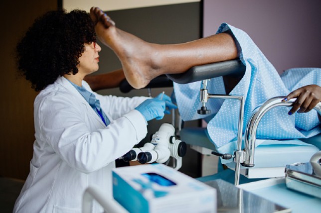 A female gynaecologist collecting samples during a smear test