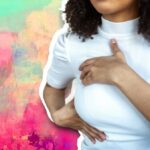 A photo of a woman checking her breast on a colourful background