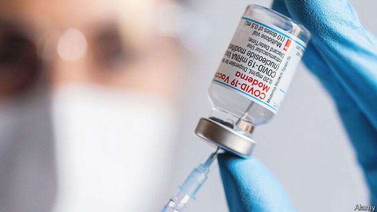 2HG9R1X A healthcare worker draws a dose from a vial of Moderna Covid-19 vaccine arranged at the vaccination center.