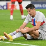 Barcelona's Robert Lewandowski sits on the pitch