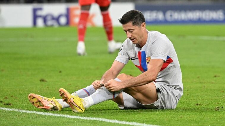 Barcelona's Robert Lewandowski sits on the pitch