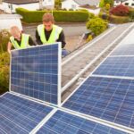 People installing solar panels on a roof