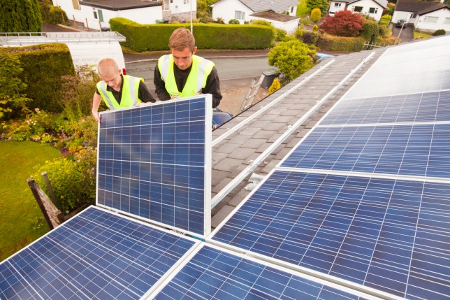 People installing solar panels on a roof