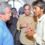 Antonio Guterres talks to people displaced by flooding and living in makeshift camps