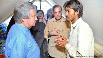 Antonio Guterres talks to people displaced by flooding and living in makeshift camps