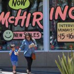 (FILES) In this file photo taken on July 08, 2022, a family walks past a "Hiring" sign at a McDonald's restaurant in Garden Grove, California. - US employers slowed the pace of hiring in August after the surprising surge in the prior month and the jobless rate edged up, the government reported on September 2, 2022. Even with the slowing pace, the job gains bring employment above the pre-pandemic level, the Labor Department said. US employment increased by 315,000 jobs last month, the report said, which was in line with what economists were expecting after the 526,000 hires in July. (Photo by Robyn BECK / AFP) (Photo by ROBYN BECK/AFP via Getty Images)