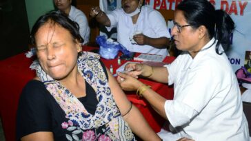 A healthcare worker administers a booster dose of COVID-19 vaccine to a beneficiary, in Guwahati.