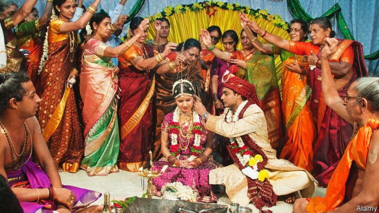 BYCEJW Guests throw rice grains over a newly married couple to symbolize abundance and good fortune at a Hindu wedding in India