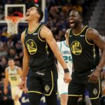 Jordan Poole #3 and Draymond Green #23 of the Golden State Warriors react after Poole made a three-point basket against the Charlotte Hornets in the first half at Chase Center on November 03, 2021 in San Francisco, California