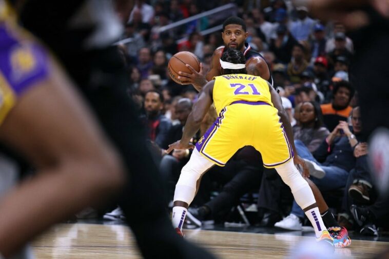 Paul George #13 of the LA Clippers looks to pass as he is guarded by Patrick Beverley #21 of the Los Angeles Lakers during a 114-101 Clippers win at Crypto.com Arena on November 09, 2022 in Los Angeles, California.