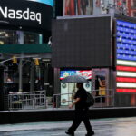 NEW YORK, NEW YORK - OCTOBER 4: A man crosses the street near Nasdaq Headquarters at Times Square on October 4, 2022 in New York City. Nasdaq led Wall Street higher as easing U.S. Treasury yields boosted megacap growth and technology stocks. (Photo by Leonardo Munoz VIEWpress/Getty Images)