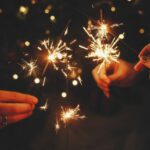 Friends celebrating with burning sparklers in hands