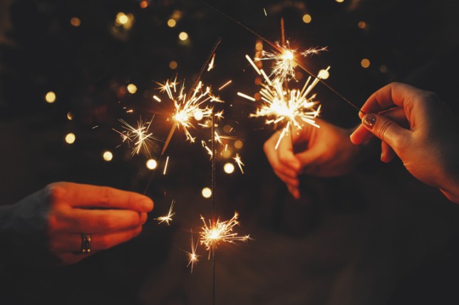 Friends celebrating with burning sparklers in hands