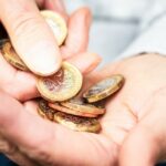 A hand counting out a pile of coins