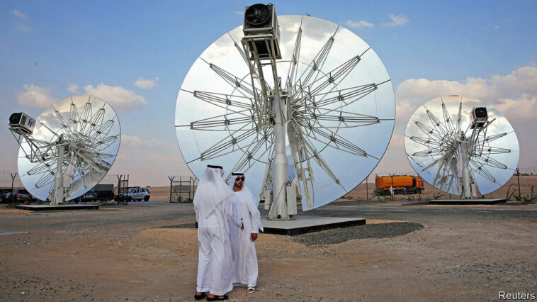 Men stand in front of solar panels at the Mohammed bin Rashid Al Maktoum Solar Park in Dubai, November 28, 2015. REUTERS/Stringer - GF20000077834