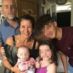 Jacqui Doyle in a kitchen with her family members. The family member's faces are blurred for anonymity