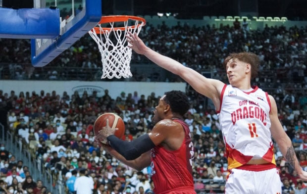 Justin Brownlee (left) sneaks in a reverse layup under the nose of Hayden Blankley as the Ginebra import sets the tone of the rout early. —PHOTOS BY AUGUST DELA CRUZ