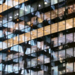 Reflection of Illuminated office building in glass office facade in Paris, France.