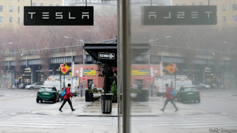 NEW YORK, NEW YORK - JANUARY 03: A man walks near Tesla showroom on January 03, 2023 in New York City. Tesla Inc. shares started 2023 by plunging more than 13% as they fell to $106.50 a share . (Photo by Leonardo Munoz/VIEWpress)