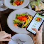 Woman uses her phone while eating a salad