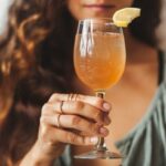 Woman holding glass of kombucha