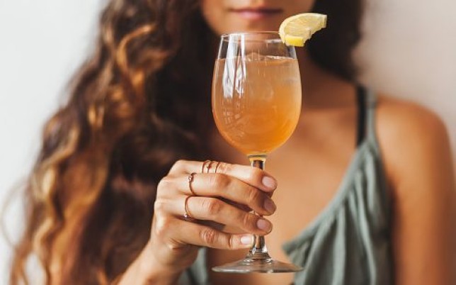 Woman holding glass of kombucha