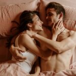 Happy young couple lying in bed