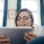 Young woman using a digital tablet on the sofa at home