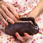 70 year old woman's hands opening purse